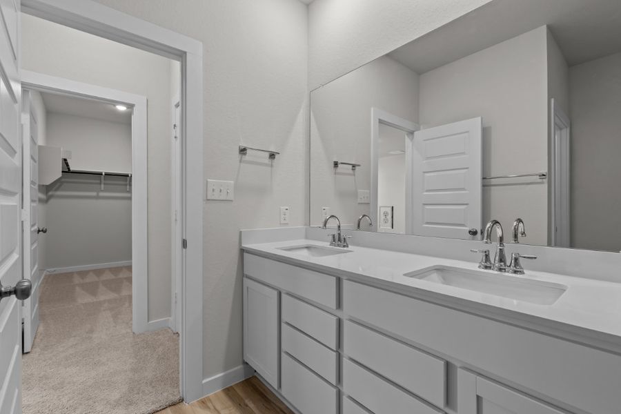A bathroom with white cabinets.