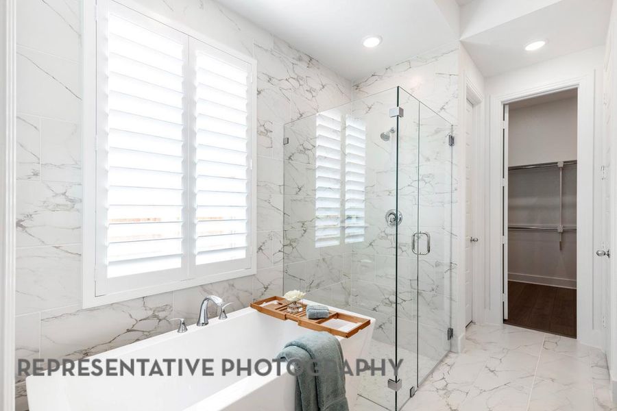 Full bathroom featuring a freestanding tub, a spacious closet, a marble finish shower, marble tiled floors, and recessed lighting Full bathroom featuring a freestanding tub, a spacious closet, a marble finish shower, marble tiled floors, and recessed lighting