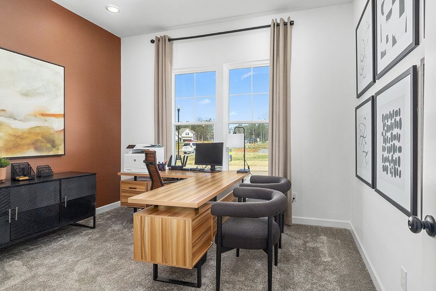 A room with a desk and chairs.