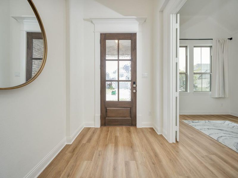 Entryway with baseboards and light wood-style floors