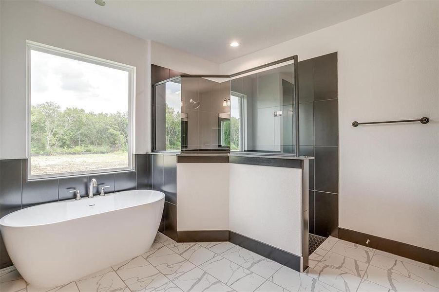 Bathroom featuring tile walls, tile flooring, and plus walk in shower