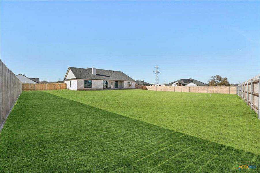 A generous, fenced backyard offers ample green space and neighborhood views. A generous, fenced backyard offers ample green space and neighborhood views.