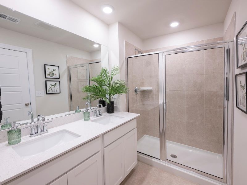The primary bath offers dual vanity sinks and a walk-in shower. Photography from Foxcroft Townes. The primary bath offers dual vanity sinks and a walk-in shower. Photography from Foxcroft Townes.