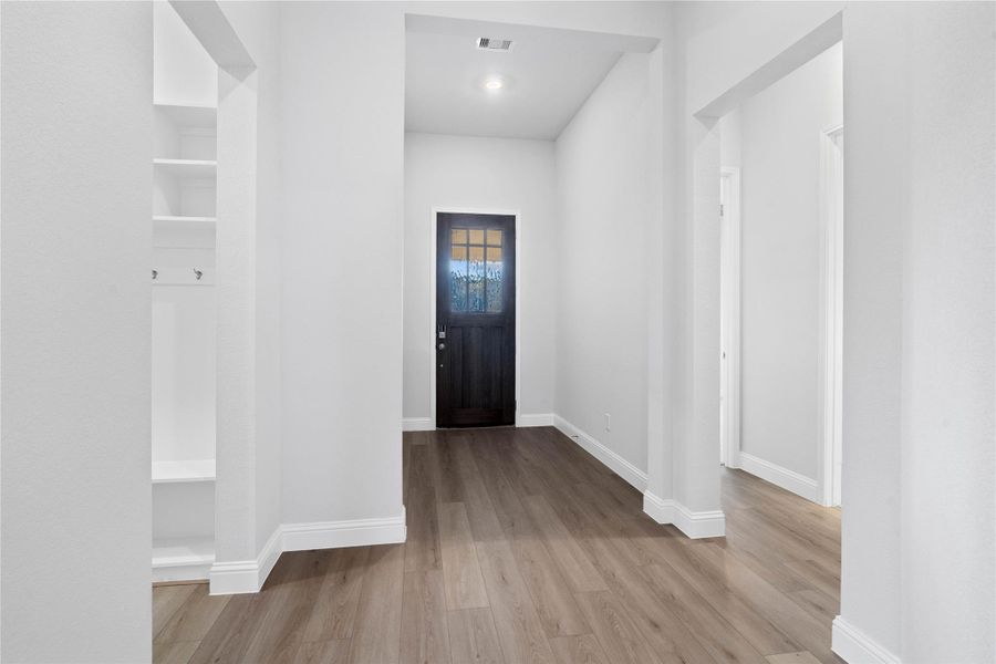 The front entryway with bedrooms on the right and mud room on the left. The front entryway with bedrooms on the right and mud room on the left.