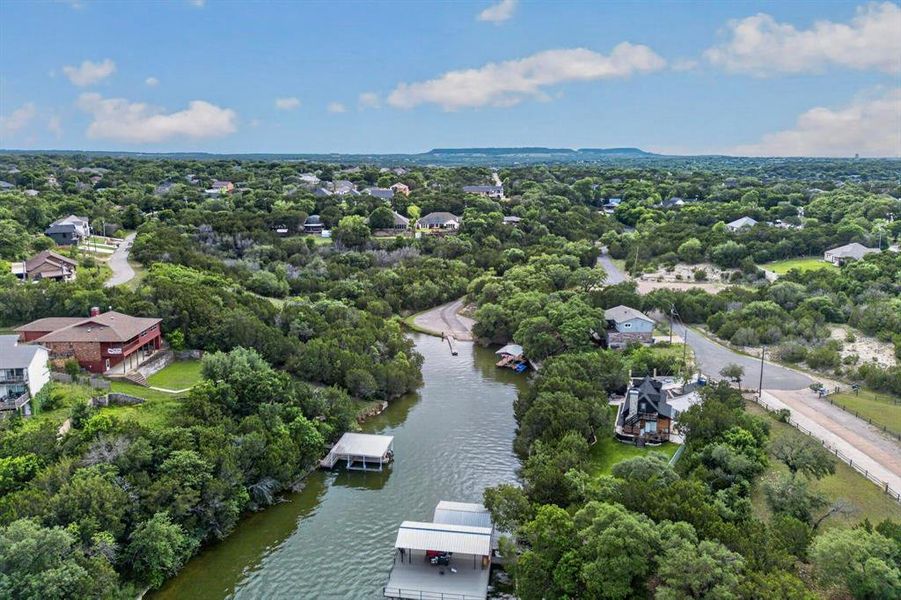 Waterfront property featuring multiple boat docks and lush, mature trees