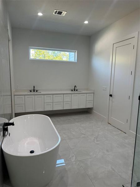 Bathroom featuring a tub and vanity