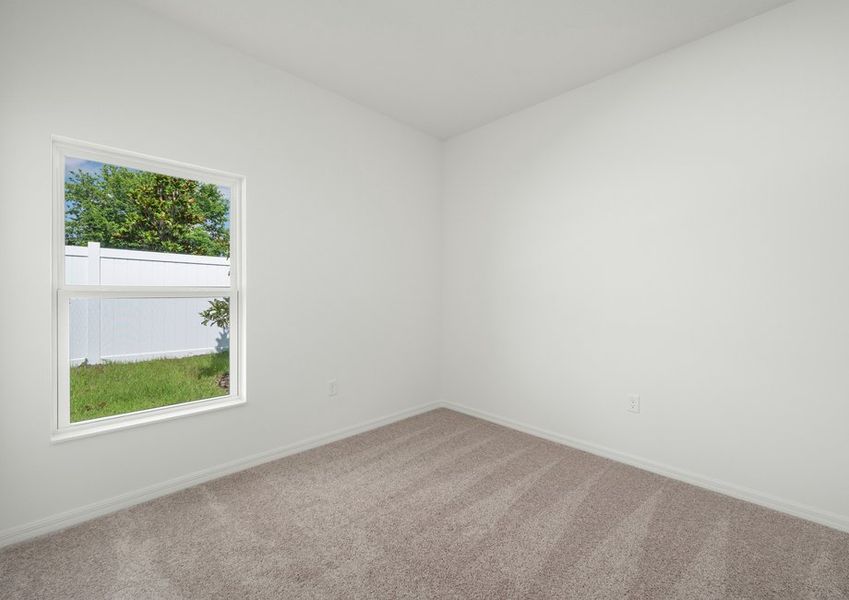 A bedroom with lush carpet flooring