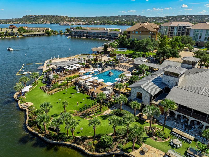 An aerial perspective reveals a luxurious lakeside retreat with an array of outdoor amenities.