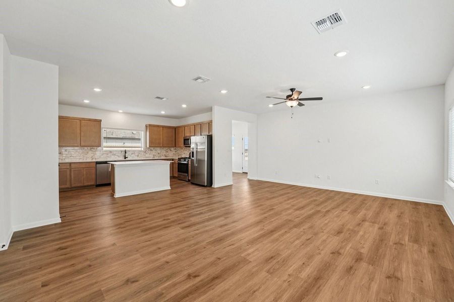 An open-concept living space with a kitchen island and wood flooring defines comfortable living. An open-concept living space with a kitchen island and wood flooring defines comfortable living.