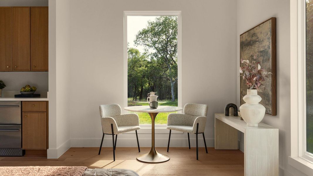 Sun-filled breakfast area with hardwood floors, a bright window overlooking green trees, and stainless steel appliances. Sun-filled breakfast area with hardwood floors, a bright window overlooking green trees, and stainless steel appliances.