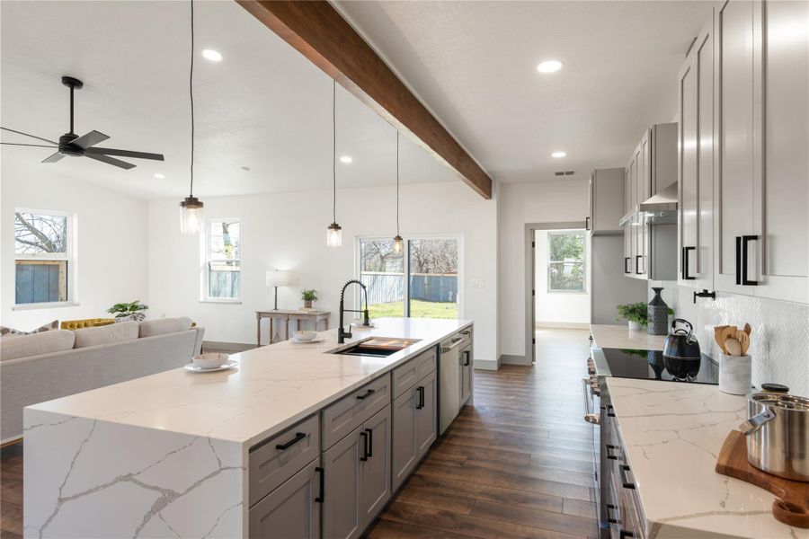 Kitchen with beam ceiling, gray cabinets, stove, a ceiling fan, and a sink