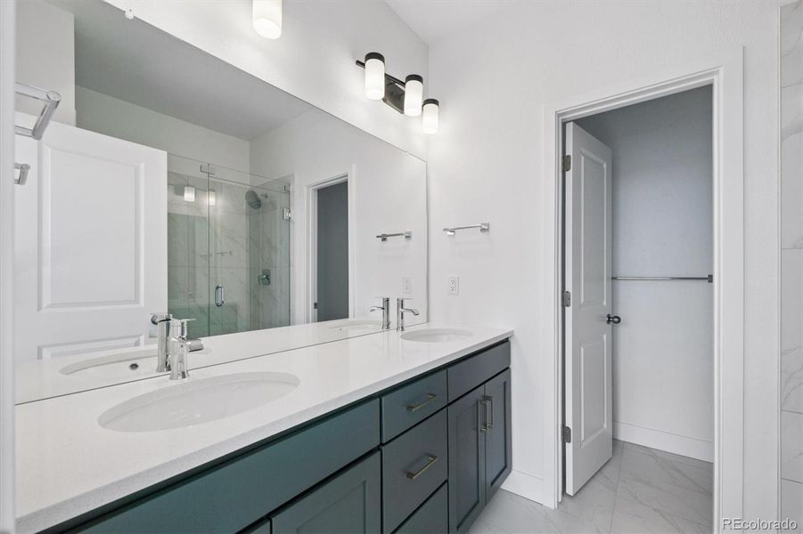 Spacious primary bathroom featuring a dual-sink vanity with quartz countertops, sleek fixtures, and a large walk-in shower for a clean, modern feel. Spacious primary bathroom featuring a dual-sink vanity with quartz countertops, sleek fixtures, and a large walk-in shower for a clean, modern feel.