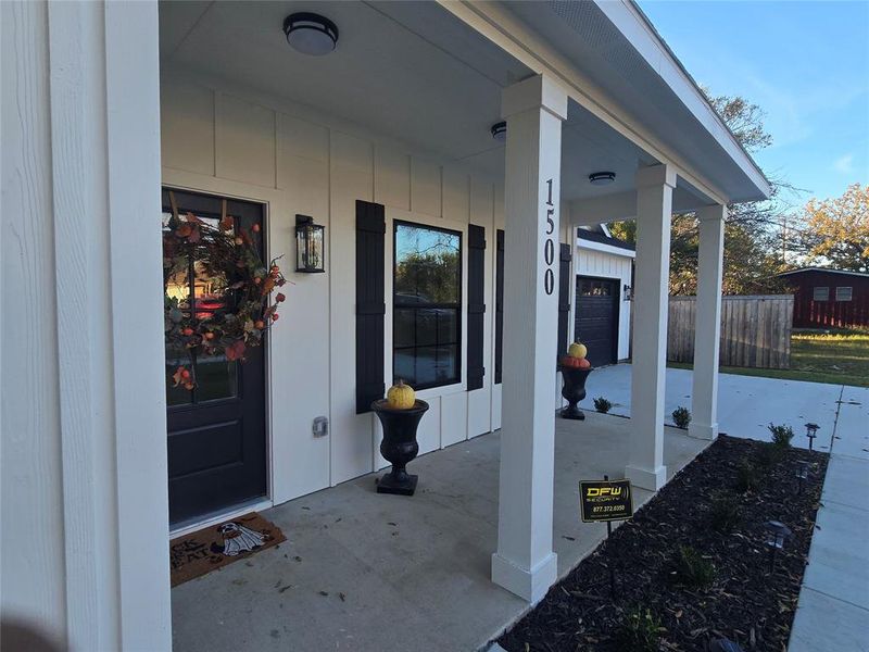 Entrance to property featuring a porch and a garage
