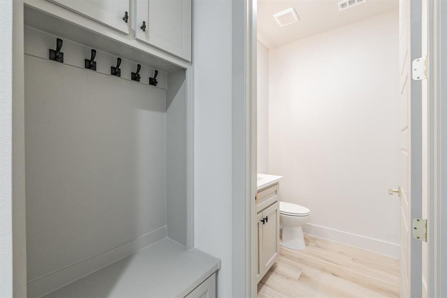 Mudroom featuring light wood-style flooring and baseboards