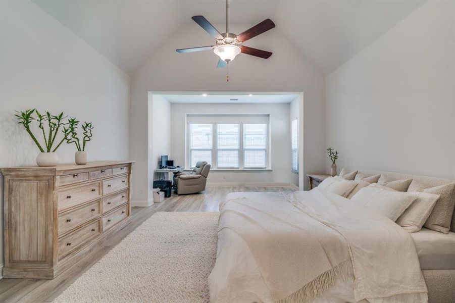Bedroom featuring light wood-type flooring, a ceiling fan, and high vaulted ceiling Bedroom featuring light wood-type flooring, a ceiling fan, and high vaulted ceiling