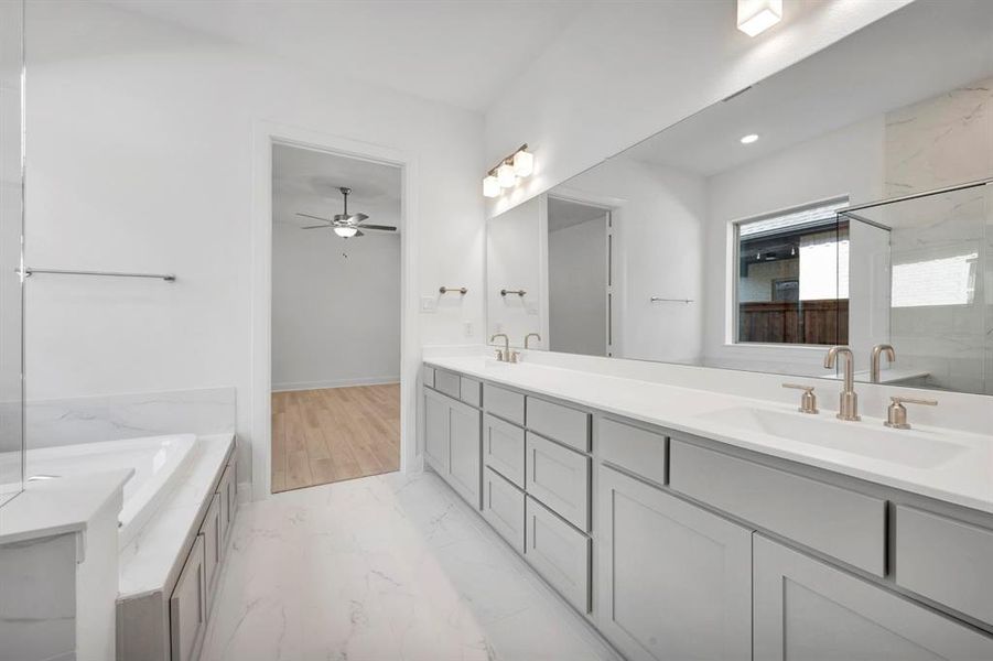 Full bathroom with double vanity, a garden tub, a marble finish shower, and light marble finish flooring Full bathroom with double vanity, a garden tub, a marble finish shower, and light marble finish flooring
