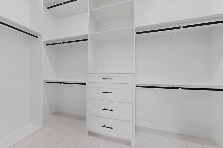 Primary Spacious closet featuring light marble finish floors Primary Spacious closet featuring light marble finish floors