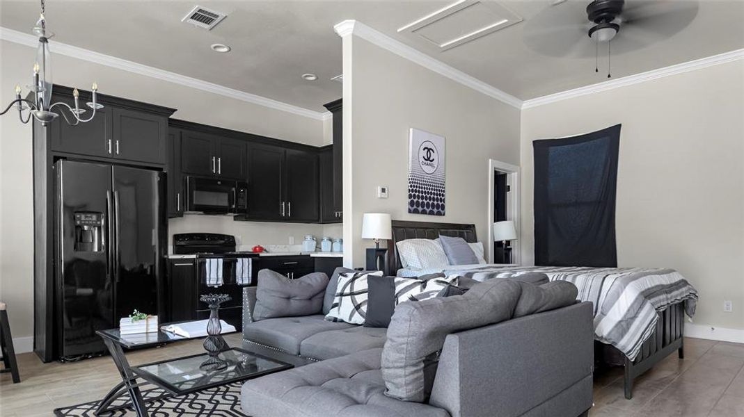 Living room with ornamental molding, a ceiling fan, recessed lighting, light wood finished floors, and a chandelier