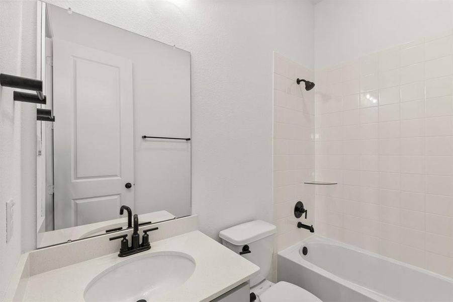 The secondary bath features tile flooring, white cabinetry and light countertops and a shower/tub combo. Perfect for accommodating any visiting family and friends.