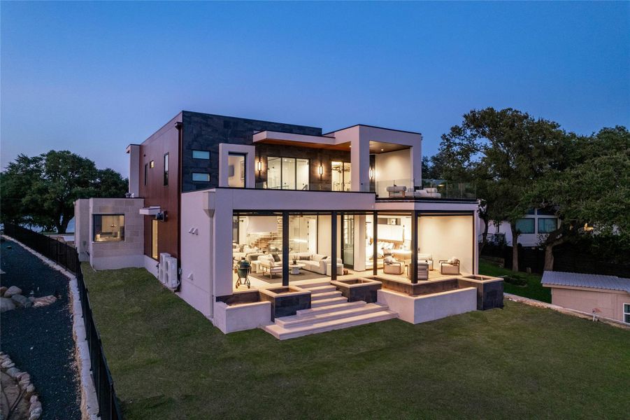 Modern architectural residence featuring multiple levels, expansive glass walls, and a flat roofline