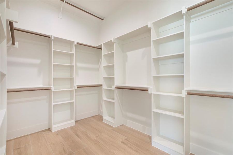 Spacious closet featuring light wood finished floors Spacious closet featuring light wood finished floors