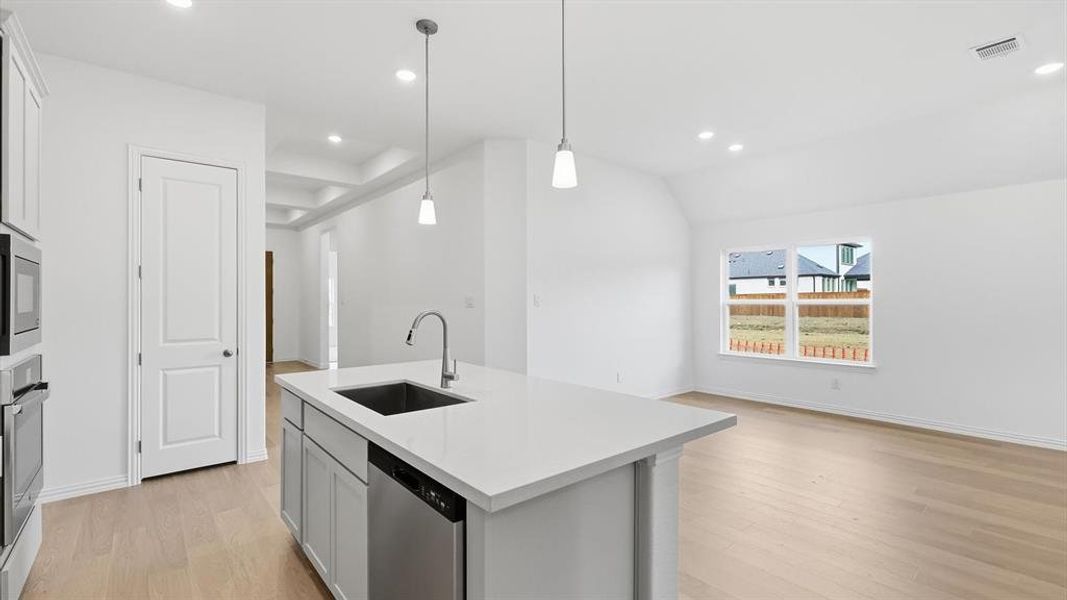Modern kitchen island featuring a stainless steel sink, gooseneck faucet, and integrated dishwasher Modern kitchen island featuring a stainless steel sink, gooseneck faucet, and integrated dishwasher