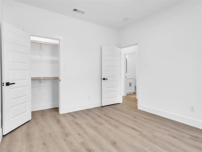 Unfurnished bedroom with baseboards, a closet, visible vents, and light wood-type flooring Unfurnished bedroom with baseboards, a closet, visible vents, and light wood-type flooring