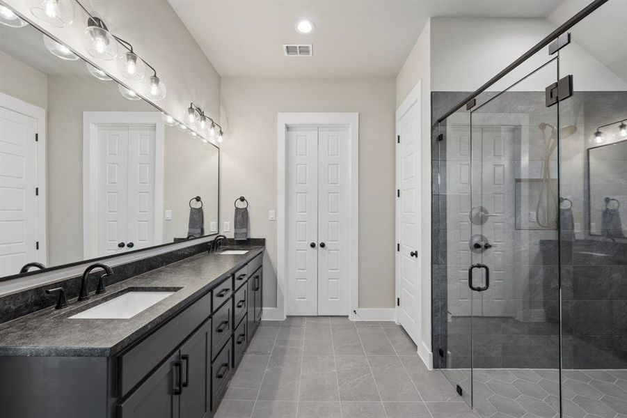 Bathroom with double vanity, a shower stall, recessed lighting, and light tile patterned flooring