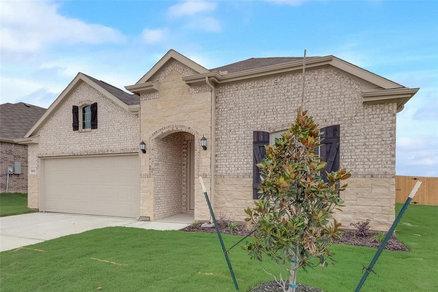 View of front of home featuring a front yard and a garage