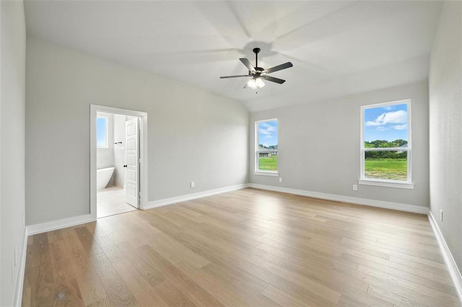 Unfurnished bedroom featuring light wood finished floors, connected bathroom, and a ceiling fan Unfurnished bedroom featuring light wood finished floors, connected bathroom, and a ceiling fan