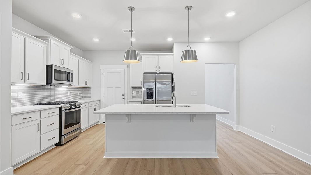 Tasteful kitchen with oversized island and stylish pendant lighting—crafted to high standards