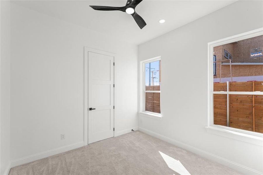 Empty room with a ceiling fan, light colored carpet, and recessed lighting