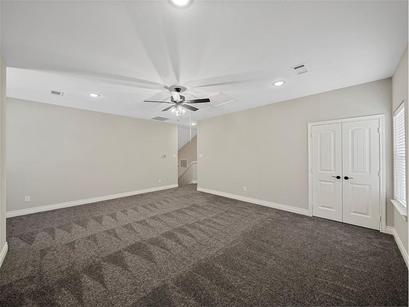 Empty room featuring recessed lighting, dark carpet, and a ceiling fan Empty room featuring recessed lighting, dark carpet, and a ceiling fan
