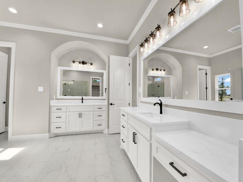 Bathroom with marble look tiles, a shower with door, crown molding, recessed lighting, and two vanities Bathroom with marble look tiles, a shower with door, crown molding, recessed lighting, and two vanities
