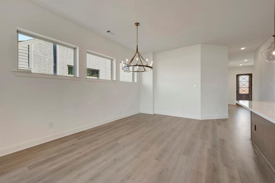 Unfurnished dining area with hanging lights and light wood finished floors Unfurnished dining area with hanging lights and light wood finished floors