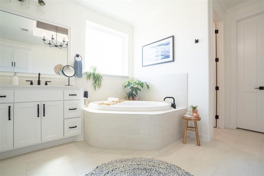 Full bathroom with ornamental molding, light tile patterned floors, a garden tub, and vanity Full bathroom with ornamental molding, light tile patterned floors, a garden tub, and vanity
