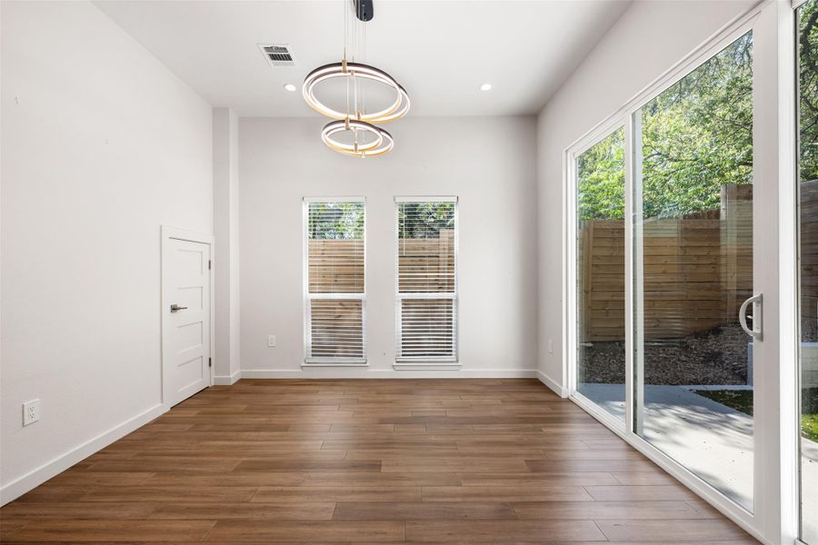 Unfurnished dining area with dark wood-style flooring and recessed lighting