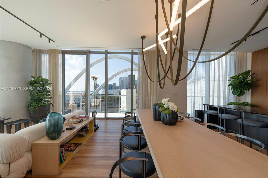 Floor-to-ceiling windows, wood-finish flooring, custom sculptural light fixture, and built-in wood cabinetry