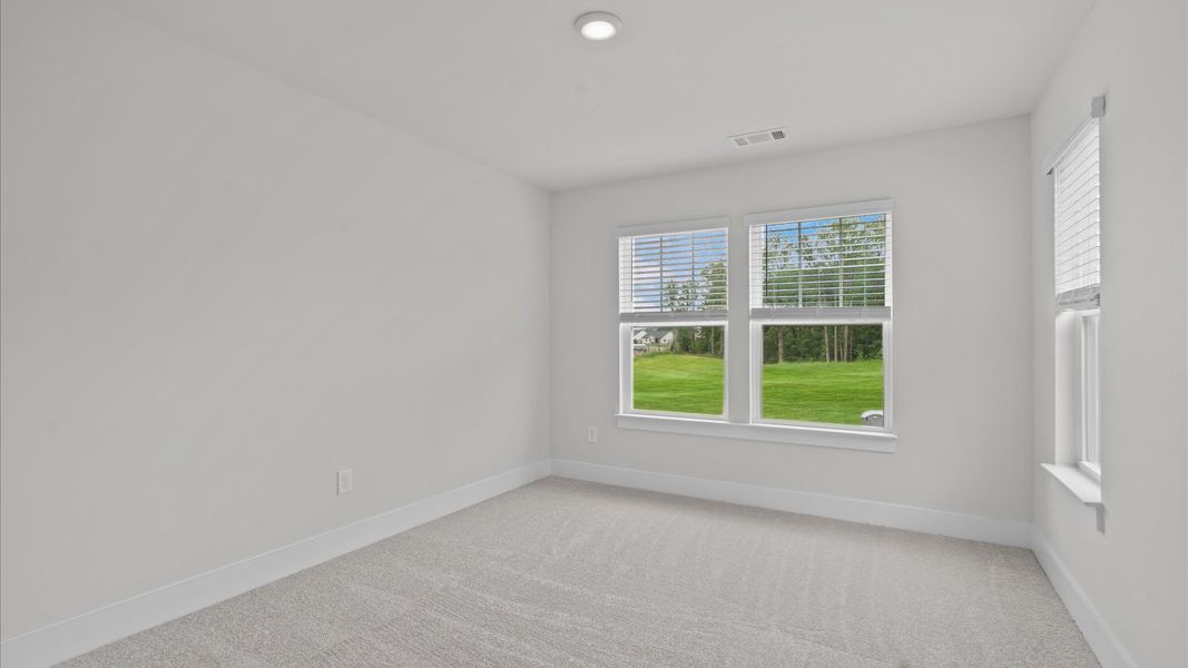 Carpeted secondary bedroom with large windows in two story townhome at Aspen Ridge by DRB Homes in Lyman, SC Carpeted secondary bedroom with large windows in two story townhome at Aspen Ridge by DRB Homes in Lyman, SC