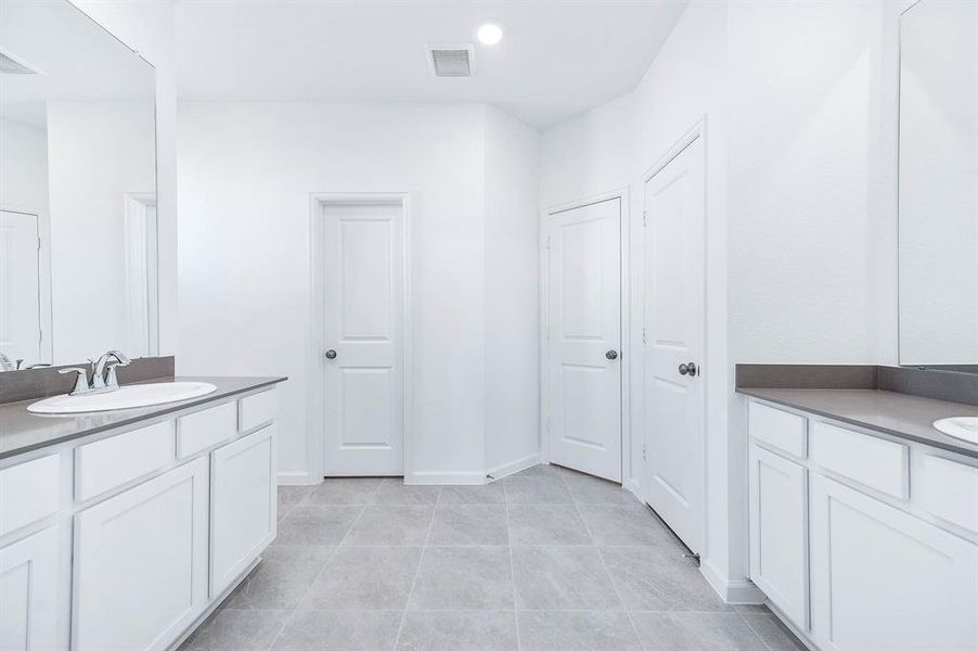 A beautifully designed bathroom featuring sleek countertops, modern fixtures, and a tiled shower with built-in shelving for your convenience.