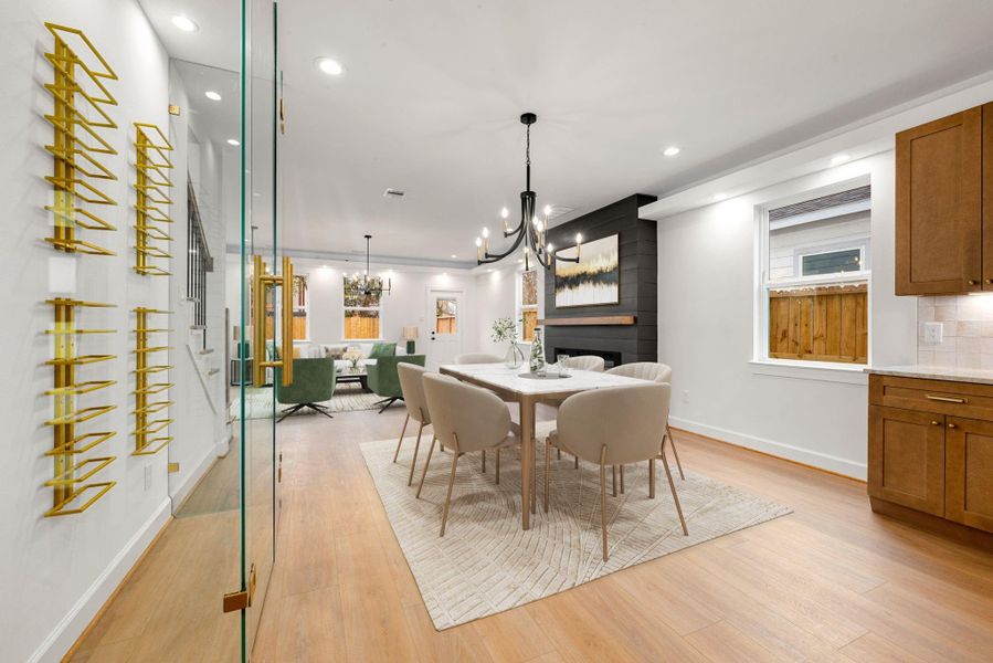 Elegant dining area seamlessly connected to the kitchen and living room, featuring warm wood floors, modern chandelier, and a spacious layout ideal for entertaining. The open-concept design offers excellent flow, abundant natural light, and stylish contemporary finishes throughout.