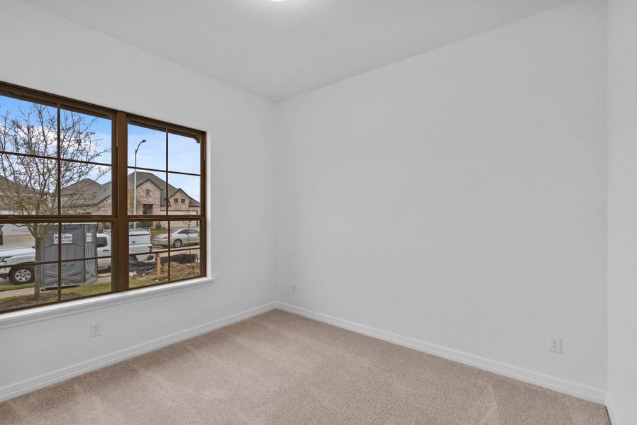 With two windows overlooking the front of the home, this secondary bedroom offers a light-filled space ideal for rest or flexibility.