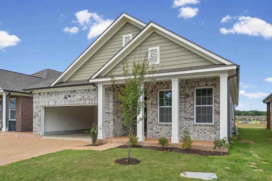 Modern craftsman-style exterior featuring a gray brick facade and sage green siding Modern craftsman-style exterior featuring a gray brick facade and sage green siding
