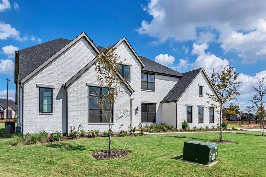 French country inspired facade featuring a front yard