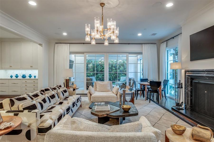 Family/Living Room with beautiful marble fireplace and chandelier overlooking the loggia