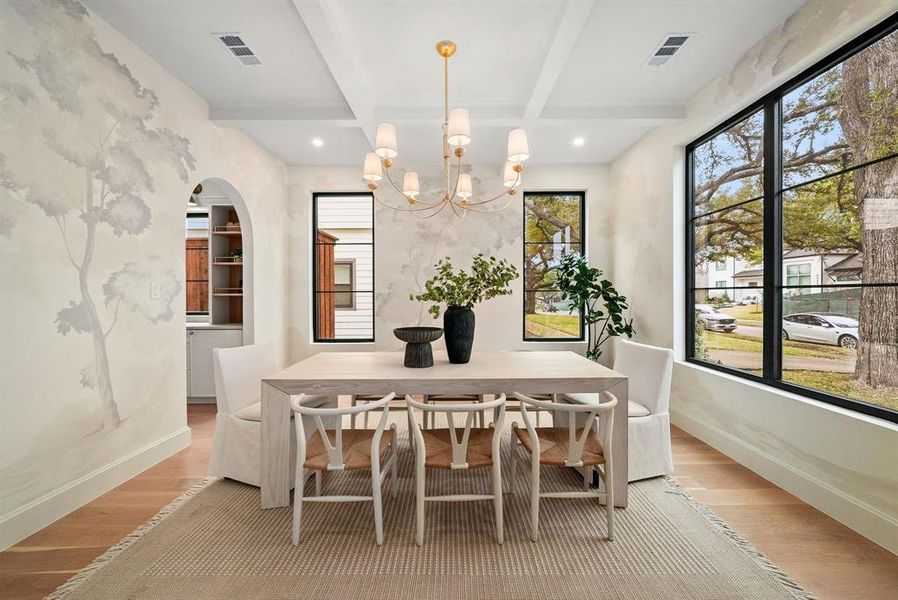 Dining room featuring arched walkways, wood finished floors, beamed ceiling, coffered ceiling, and a chandelier Dining room featuring arched walkways, wood finished floors, beamed ceiling, coffered ceiling, and a chandelier