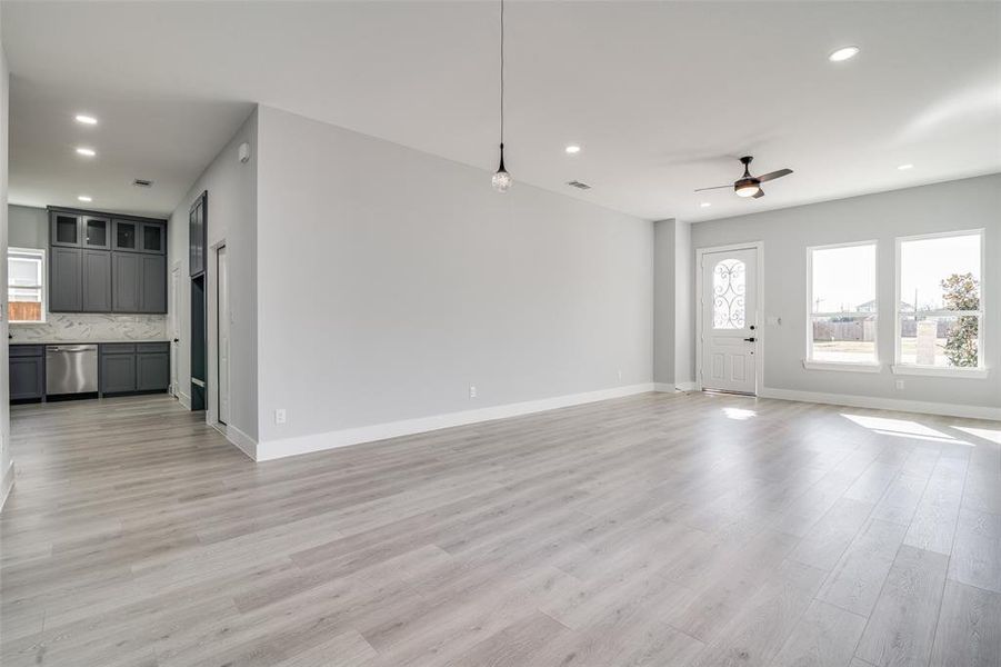 Unfurnished living room featuring ceiling fan and light hardwood / wood-style floors