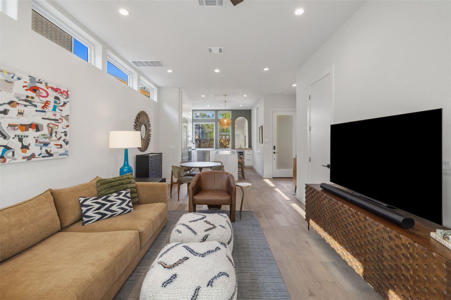 Living room featuring recessed lighting, light wood-style flooring, and arched walkways