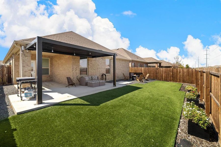Back of house featuring a patio area, a fenced backyard, brick siding, and an outdoor living space Back of house featuring a patio area, a fenced backyard, brick siding, and an outdoor living space