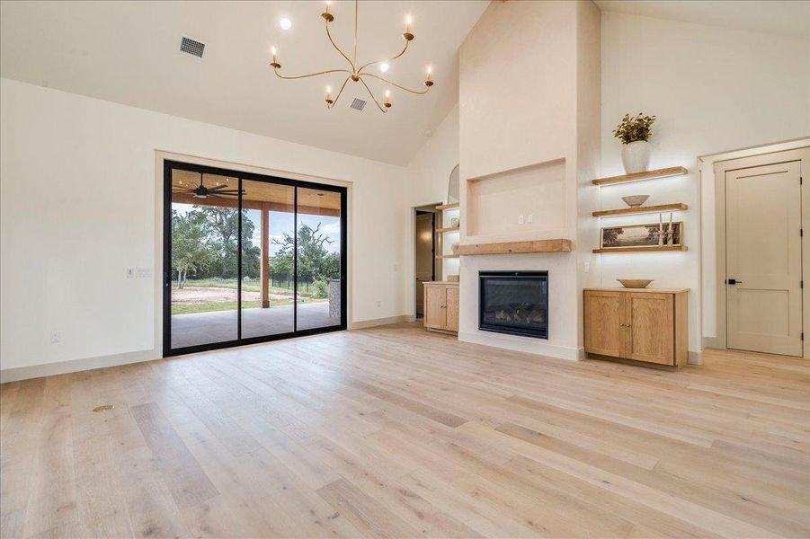 Hardwood floors and a towering fireplace define this spacious living area with outdoor access.